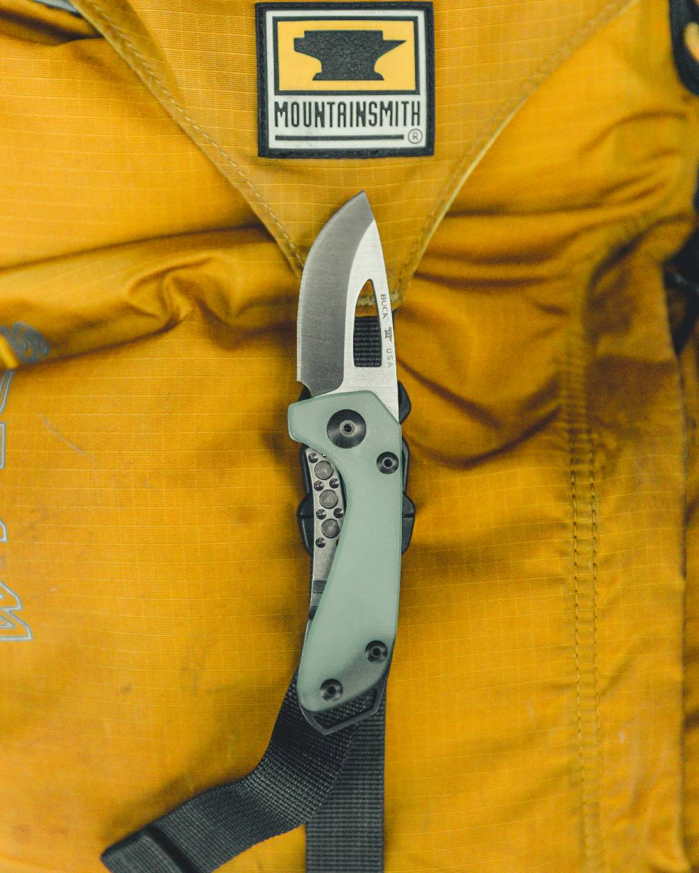 Natural coloured Buck Budgie Knife on bag background