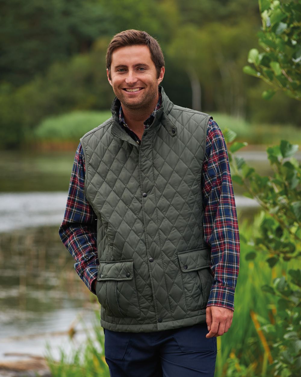 Olive coloured Champion Ashby Quilted Body Warmer on forest background