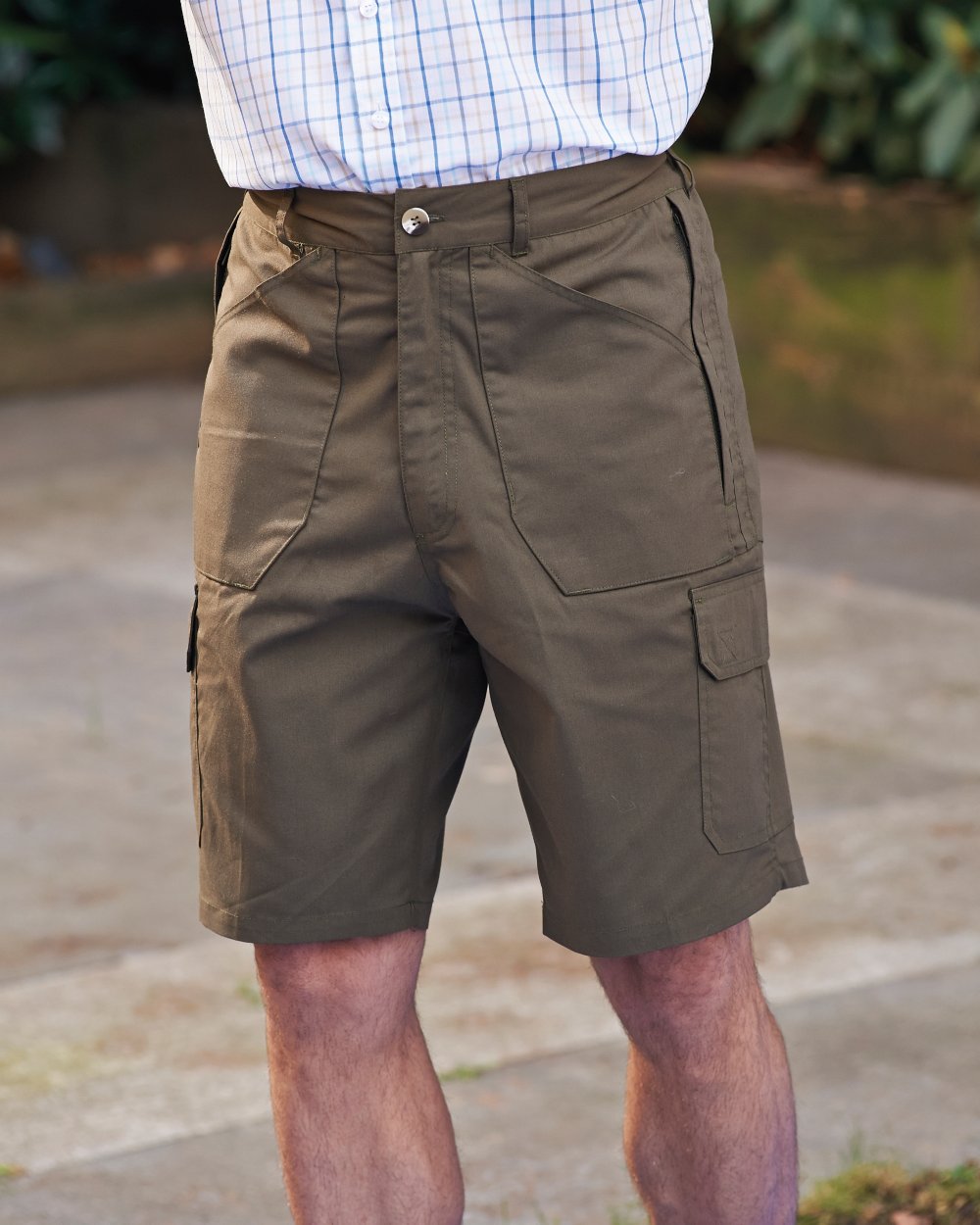 Olive coloured Champion Bretton Multi-Pocket Activity Shorts on backyard background