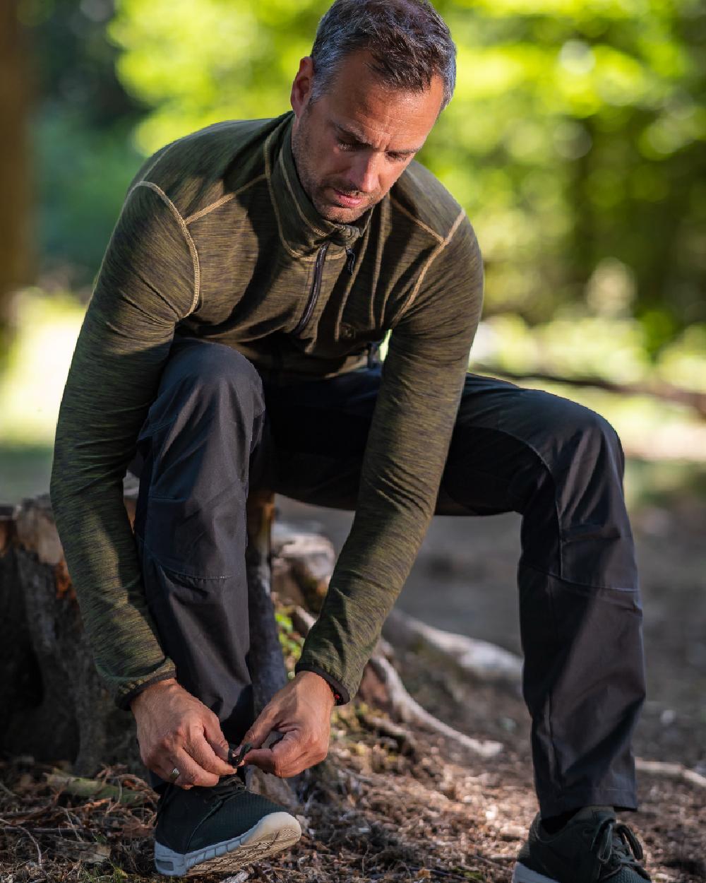 Black coloured Deerhunter Strike Full Stretch Trousers on forest background