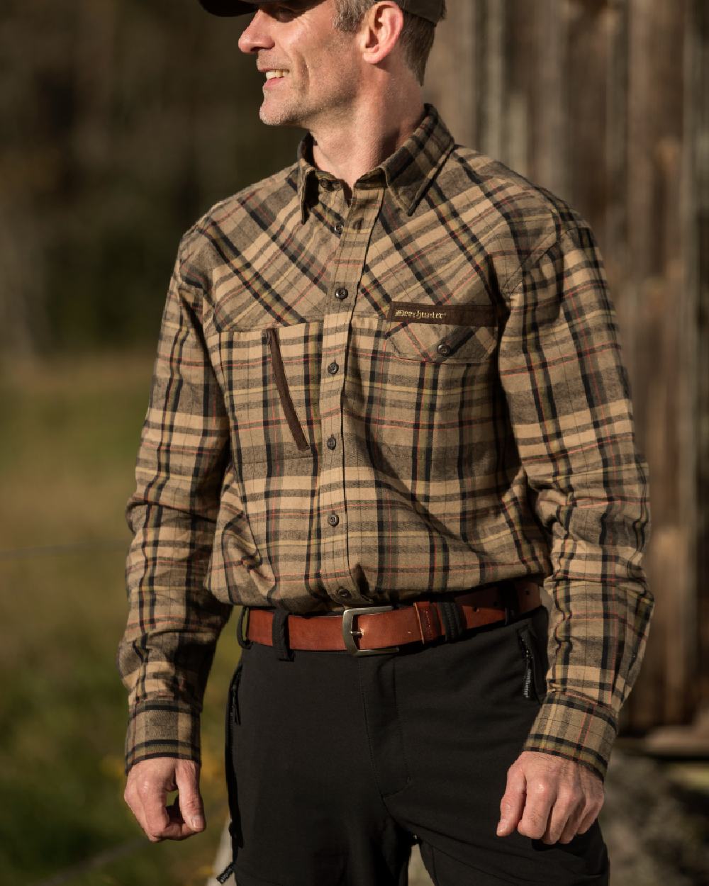 Black coloured Deerhunter Strike Full Stretch Trousers on forest background