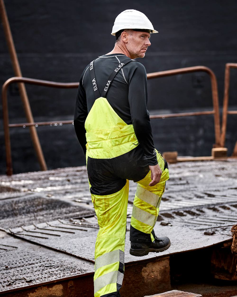 Fluorescent Yellow Black Coloured Elka Mens Visible Xtreme Stretch Combi Trousers on construction background