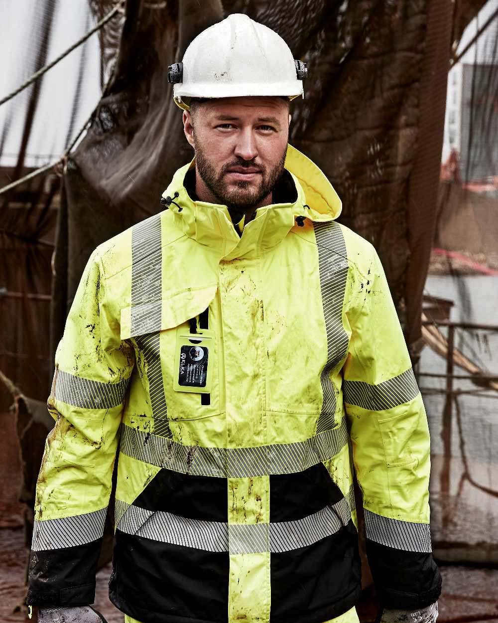 Fluorescent Yellow Black Coloured Elka Mens Visible Xtreme Stretch Jacket on construction background