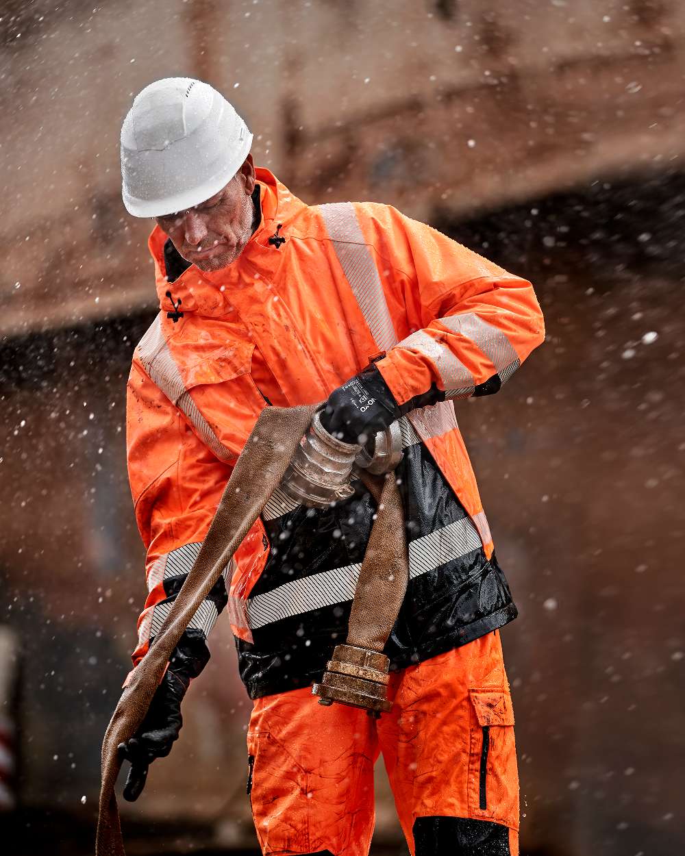 Fluorescent Orange Black Coloured Elka Mens Visible Xtreme Stretch Winter Jacket on blurry background