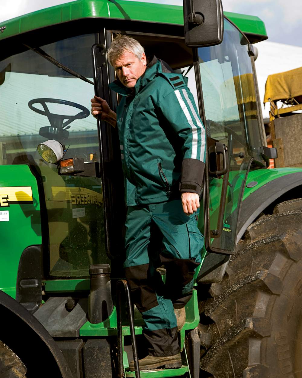 Green Black Coloured Elka Mens Working Xtreme 2-In-1 Jacket on tractor background