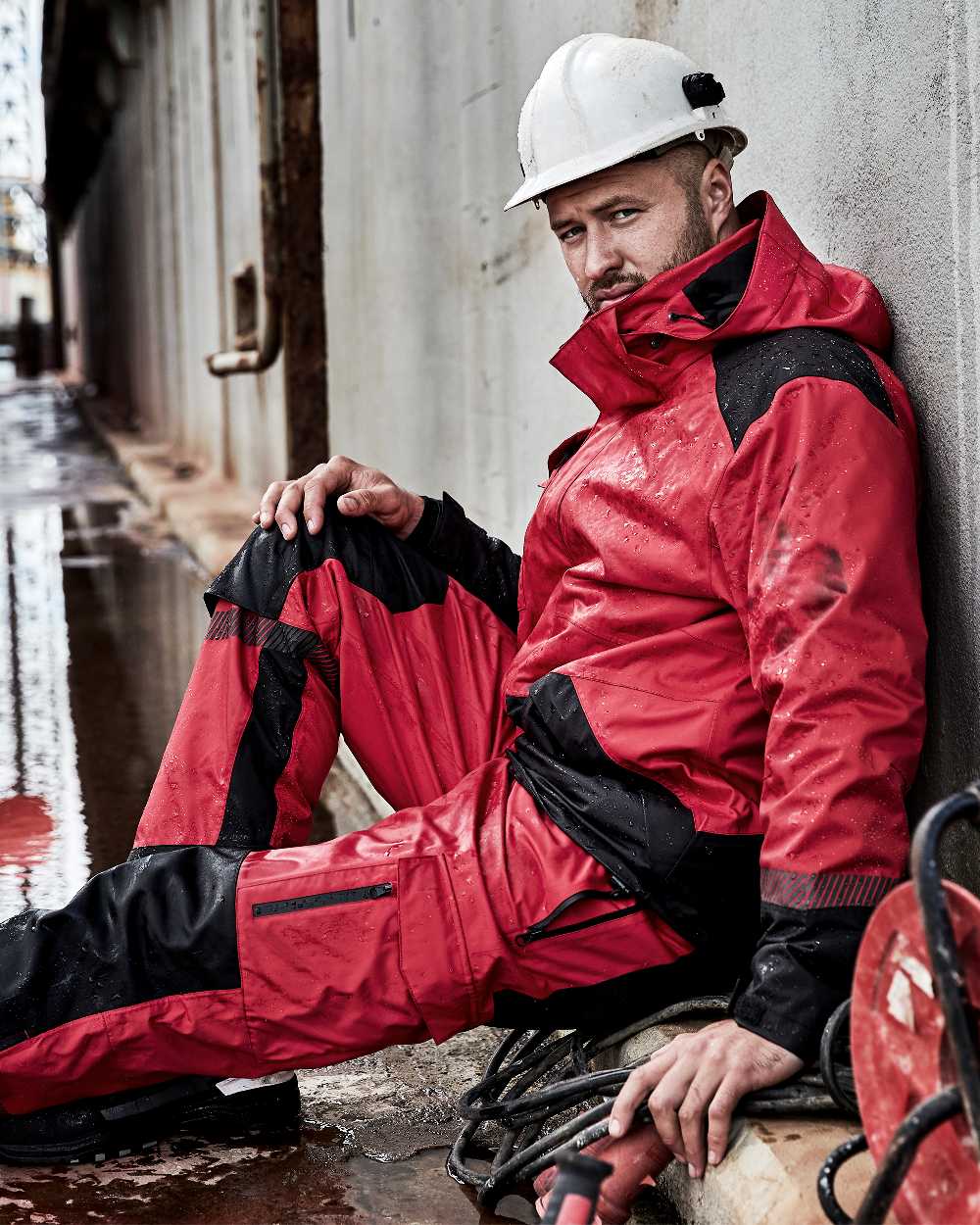 Red Black Coloured Elka Mens Working Xtreme Stretch Jacket on construction background