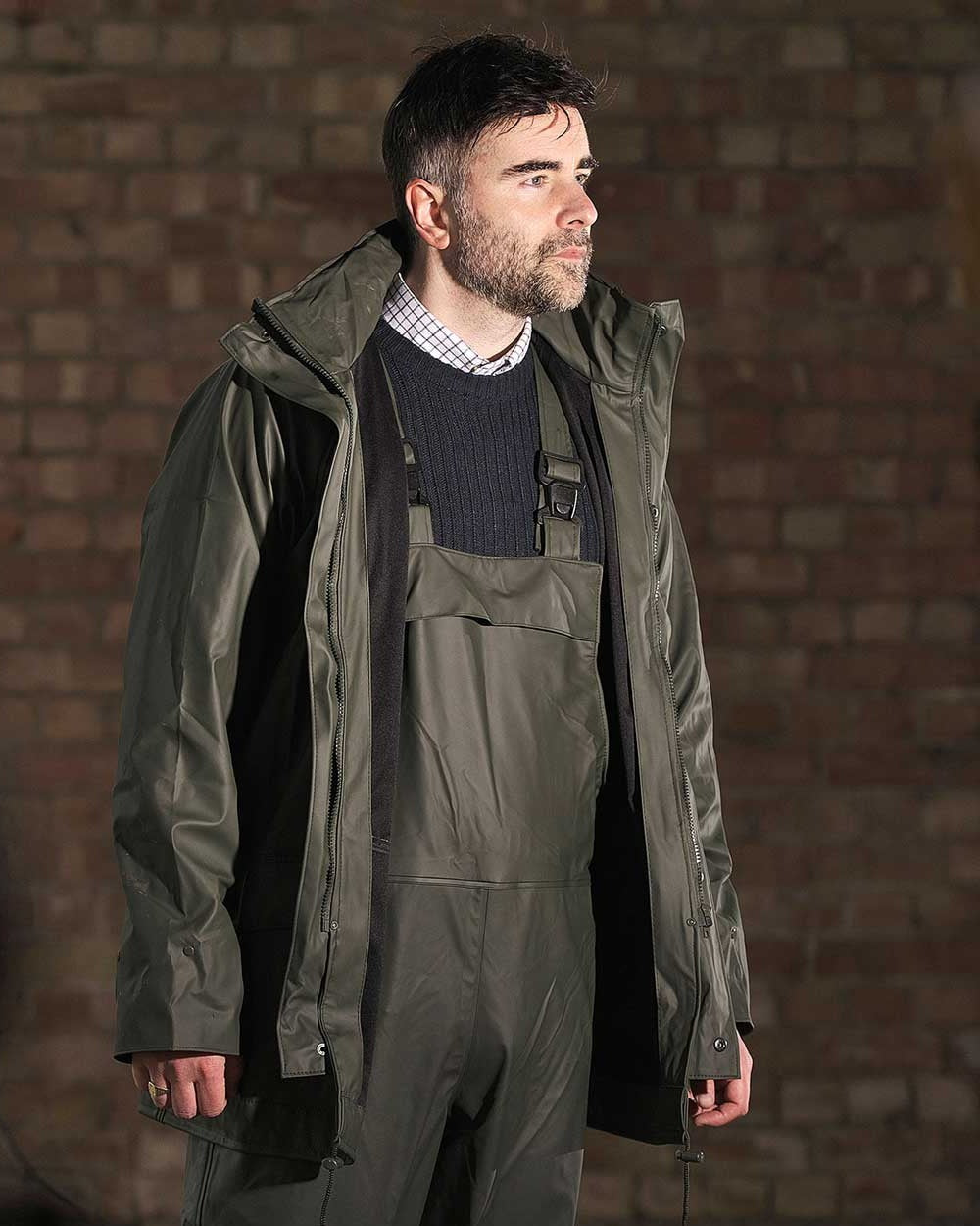 Olive coloured Fort Airflex Waterproof Breathable Bib and Brace Overalls on brick background