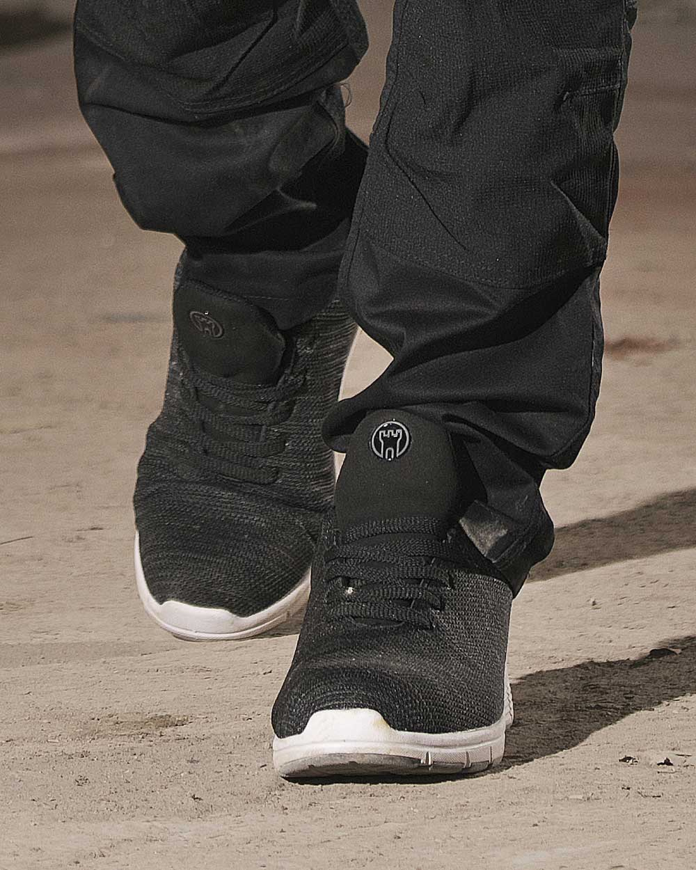 Black coloured Fort Elite Safety Trainer on brown background