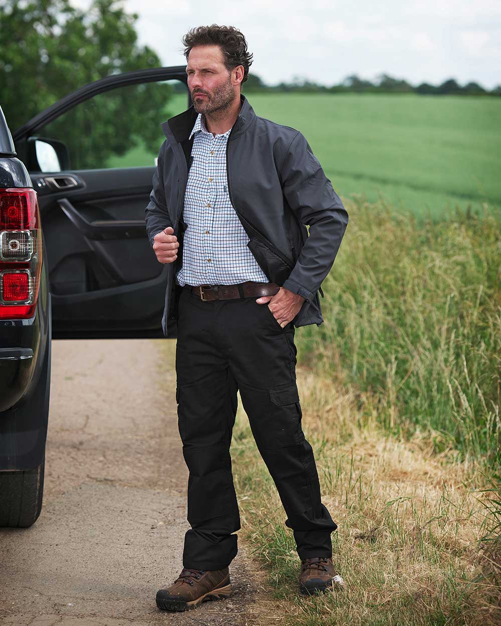 Black coloured Fort Workforce Trousers on field background
