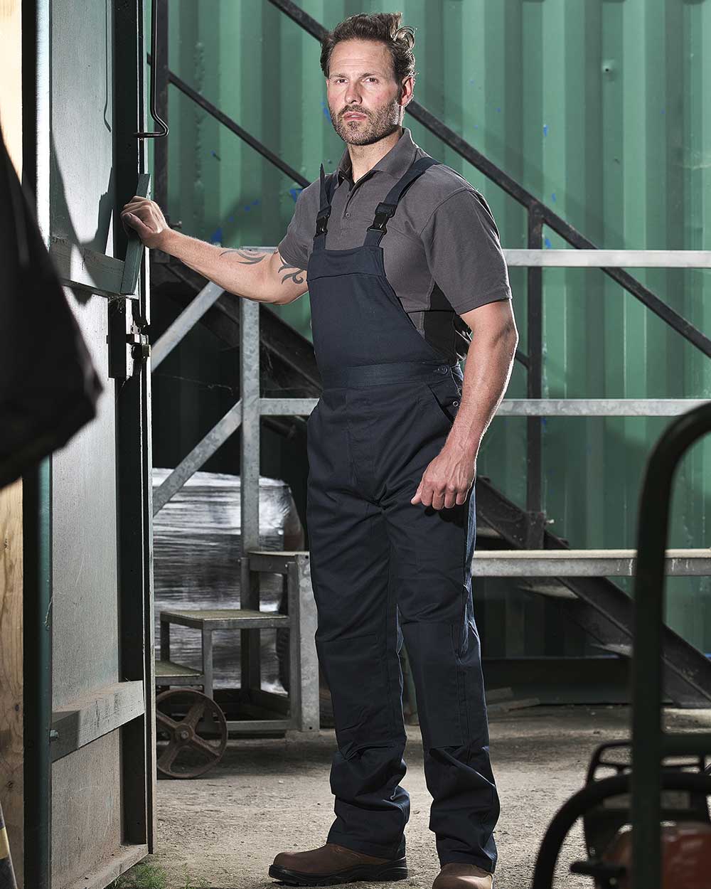 Navy coloured Fort Bib & Brace Overall Polycotton on green background