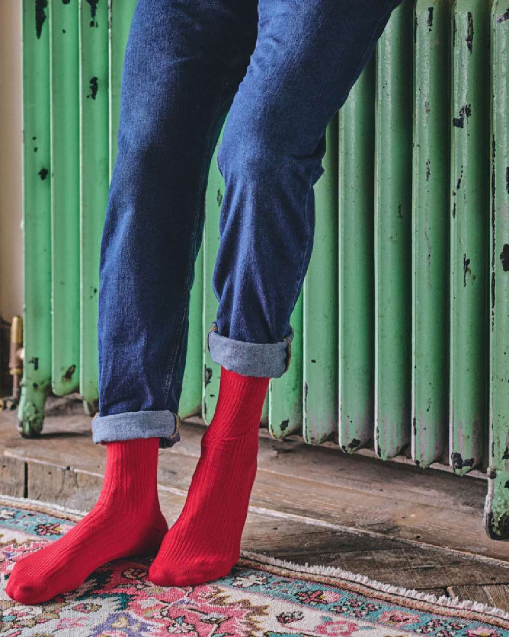 Red coloured HJ Hall Mens Original Bamboo Softop Socks on Green wall background