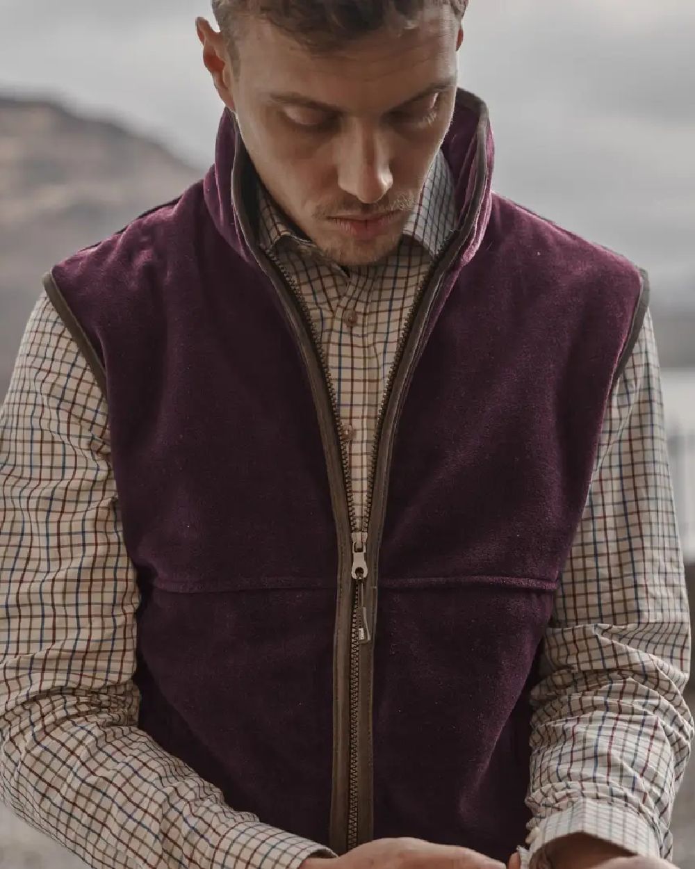 Merlot coloured Hoggs of Fife Stenton Technical Fleece Gilet on blurry background