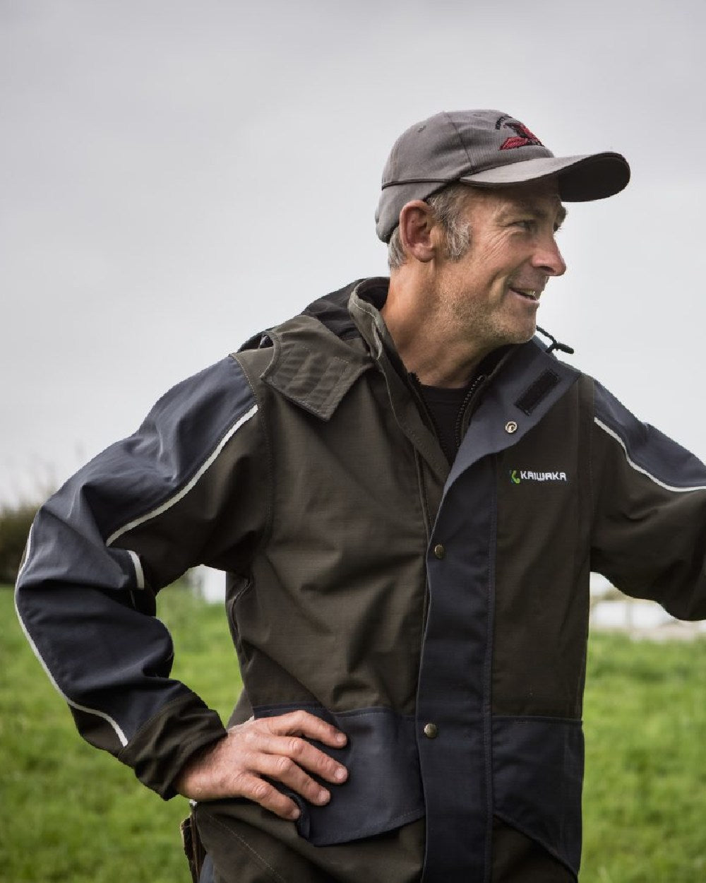 Olive coloured Kaiwaka Mens Stormforce Parka on grassy background