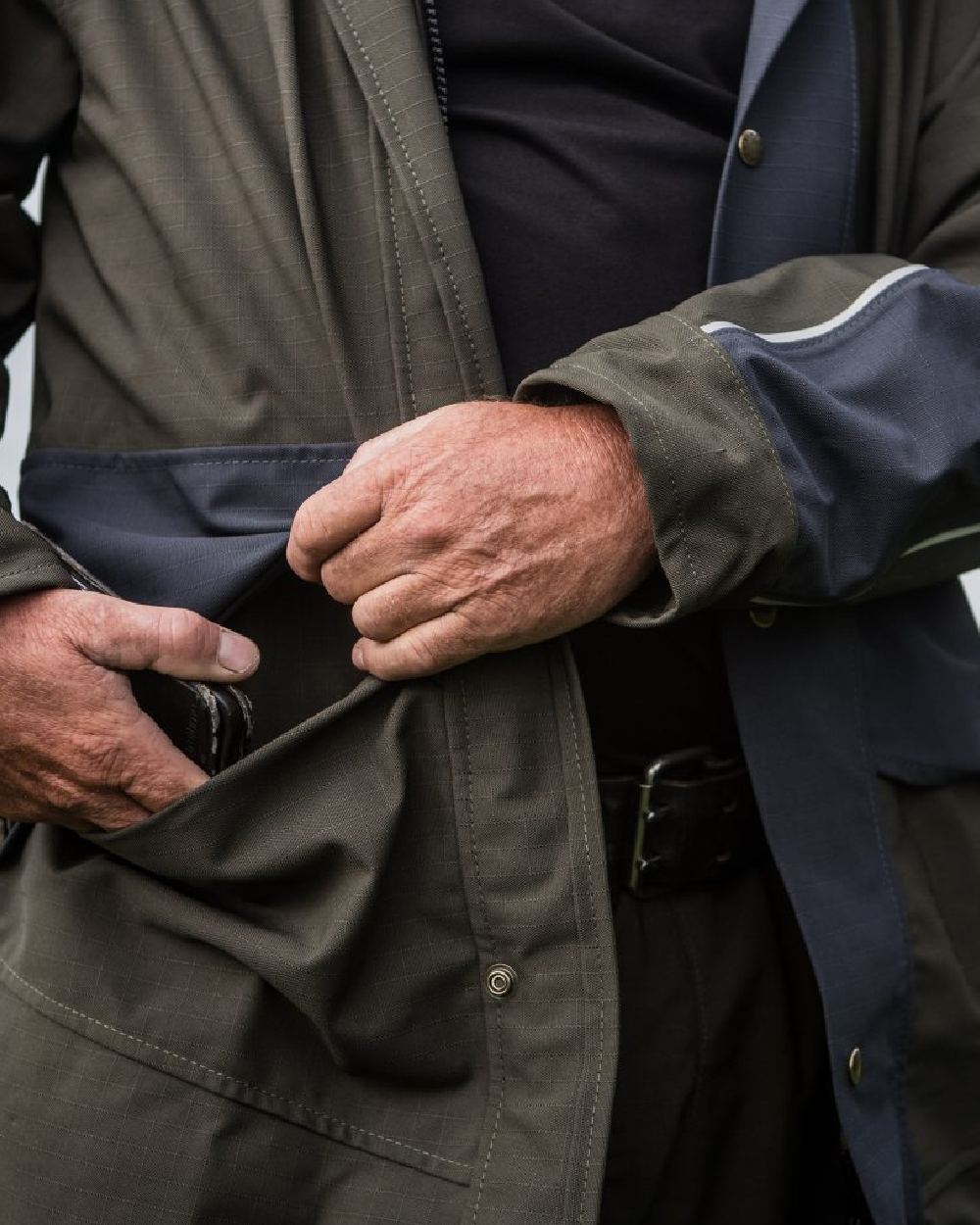 Olive coloured Kaiwaka Mens Stormforce Parka on blurry background