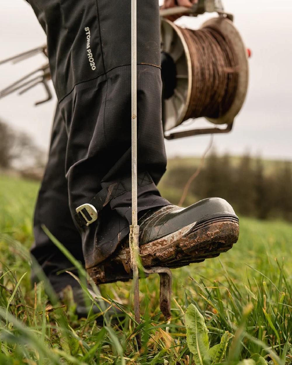 Black coloured Line 7 Mens Territory Storm Pro20 Waterproof Overtrouser on farm background