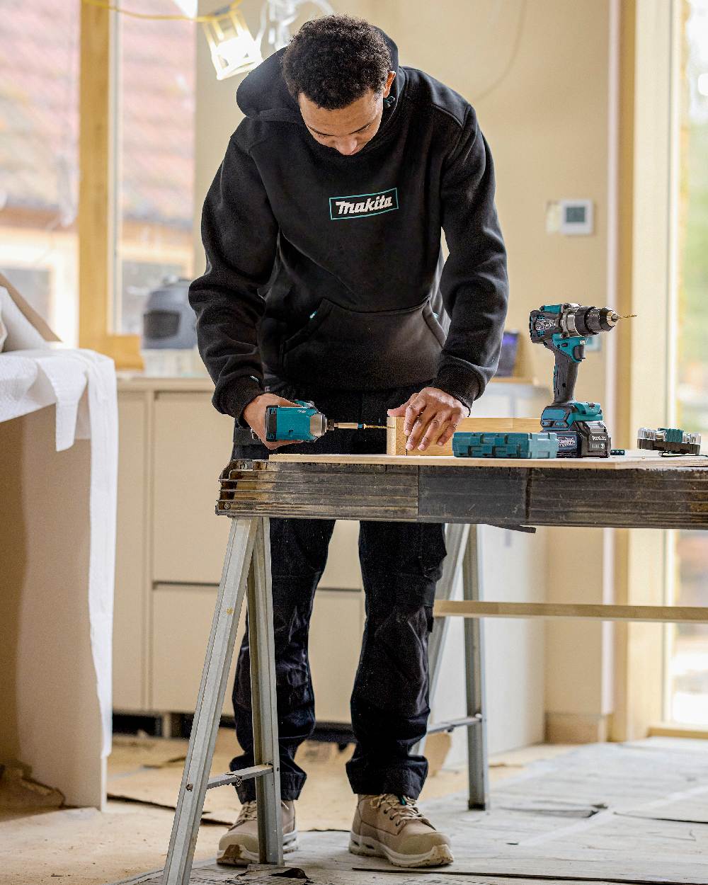 Black Coloured Makita Mens Origin Hoodie on construction background
