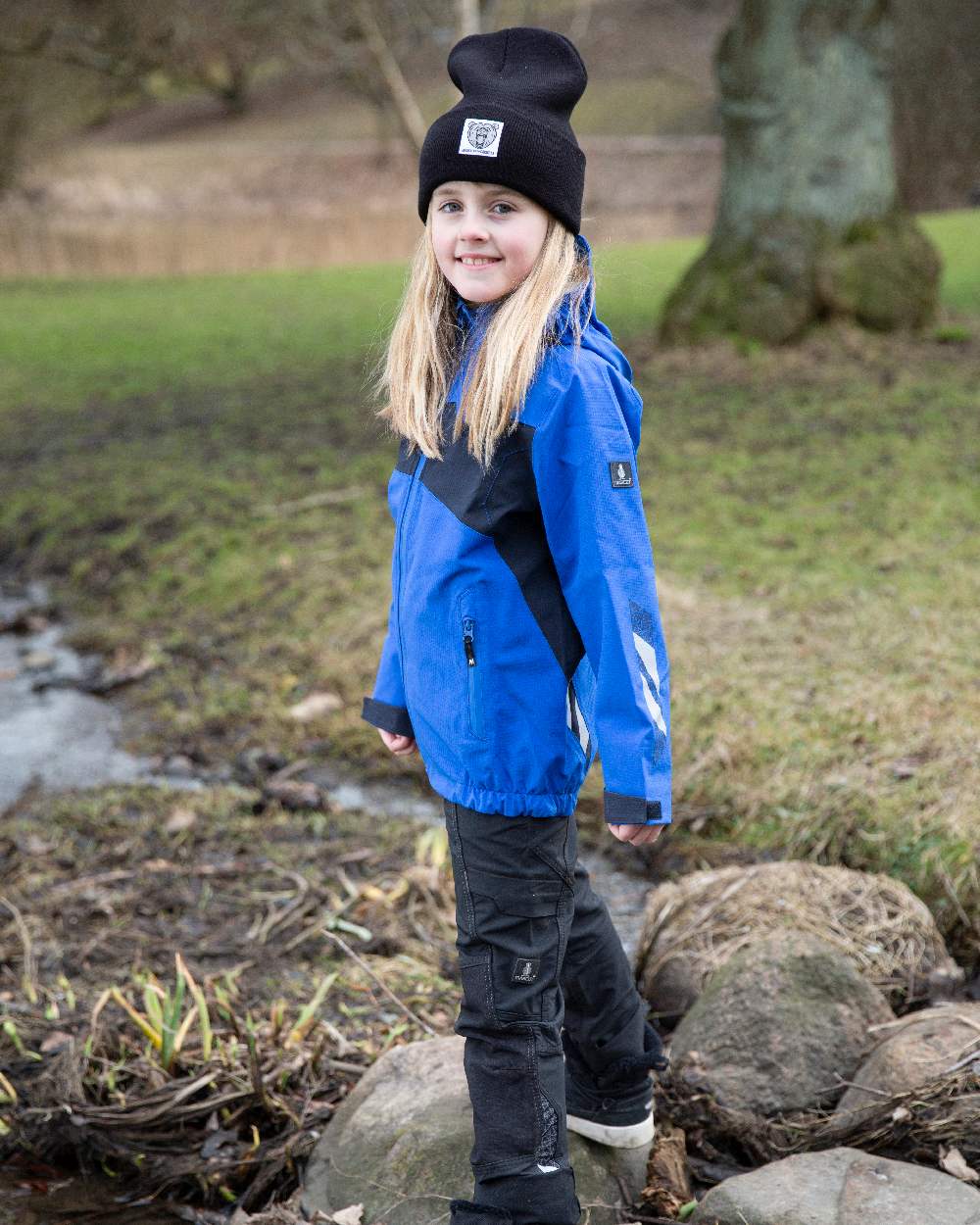 Azure Blue Dark Navy Coloured Mascot Workwear Childrens Accelerate Lightweight Outer Shell Jacket on outdoor background