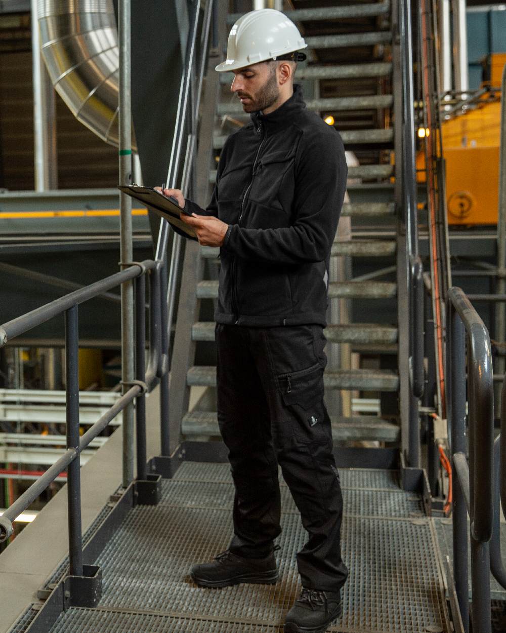 Black Coloured Mascot Workwear Mens Accelerate Fleece Jacket on factory background