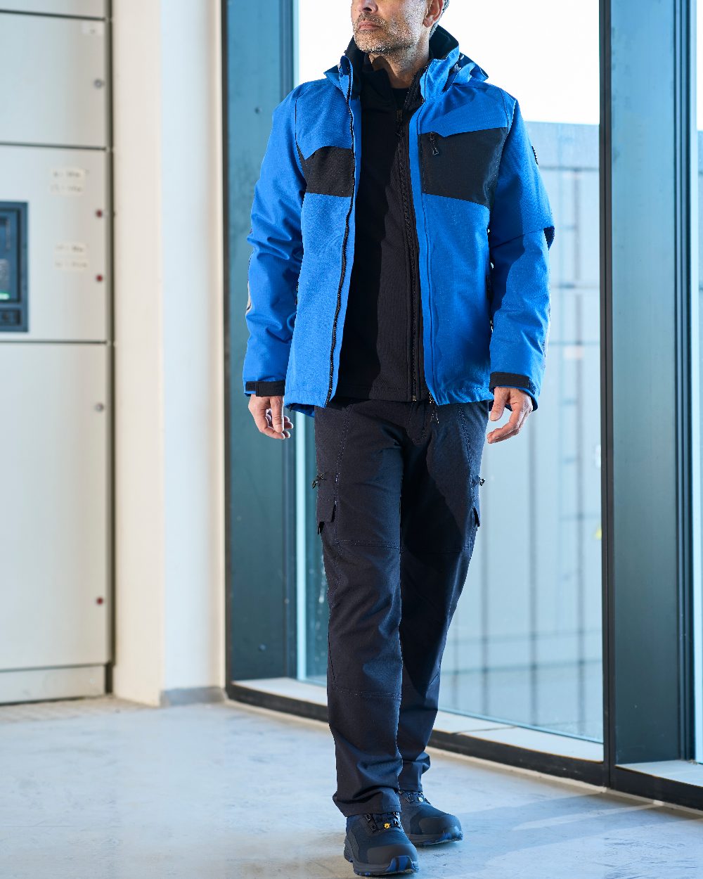 Dark Navy Coloured Mascot Workwear Mens Accelerate Lightweight Trousers With Thigh Pockets on factory background