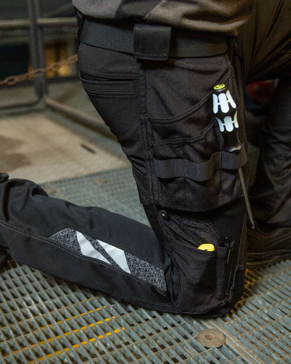 Black Coloured Mascot Workwear Mens Accelerate Trousers With Holster Pockets on factory background