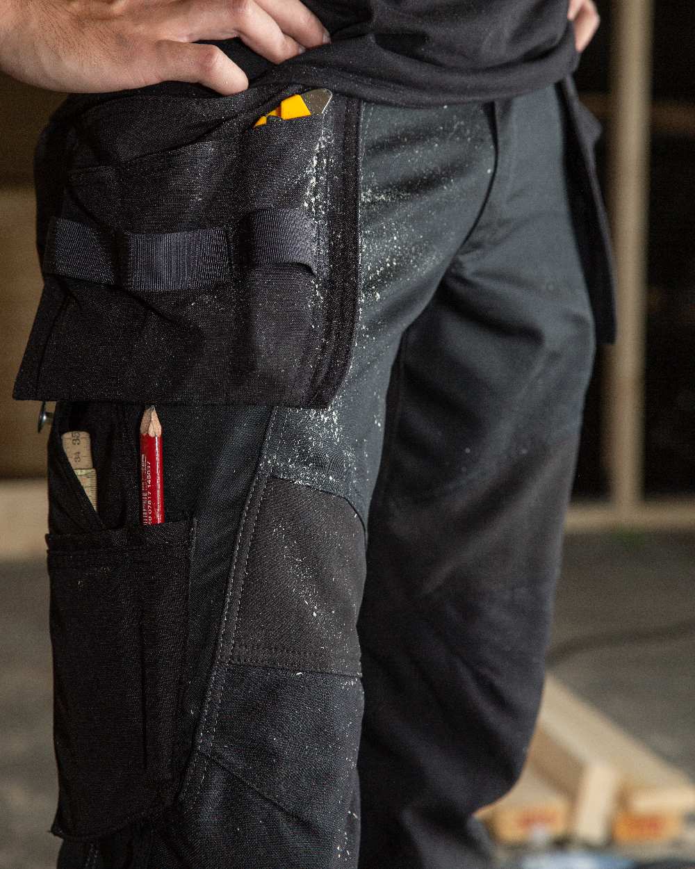 Black Coloured Mascot Workwear Mens Accelerate Trousers With Holster Pockets on factory background