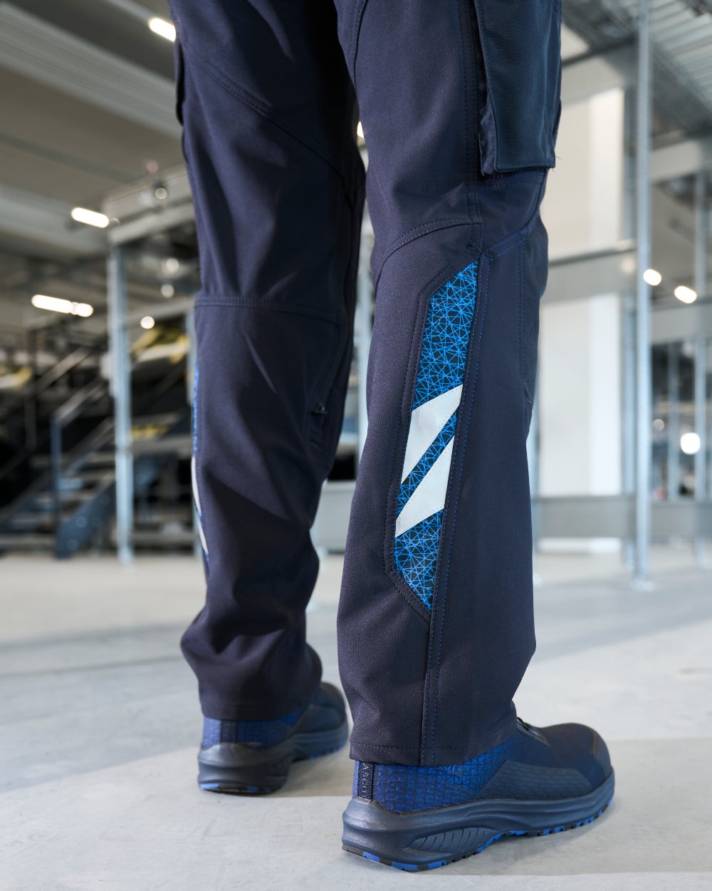 Dark Navy Coloured Mascot Workwear Mens Accelerate Ultimate Stretch Lightweight Trousers on factory background