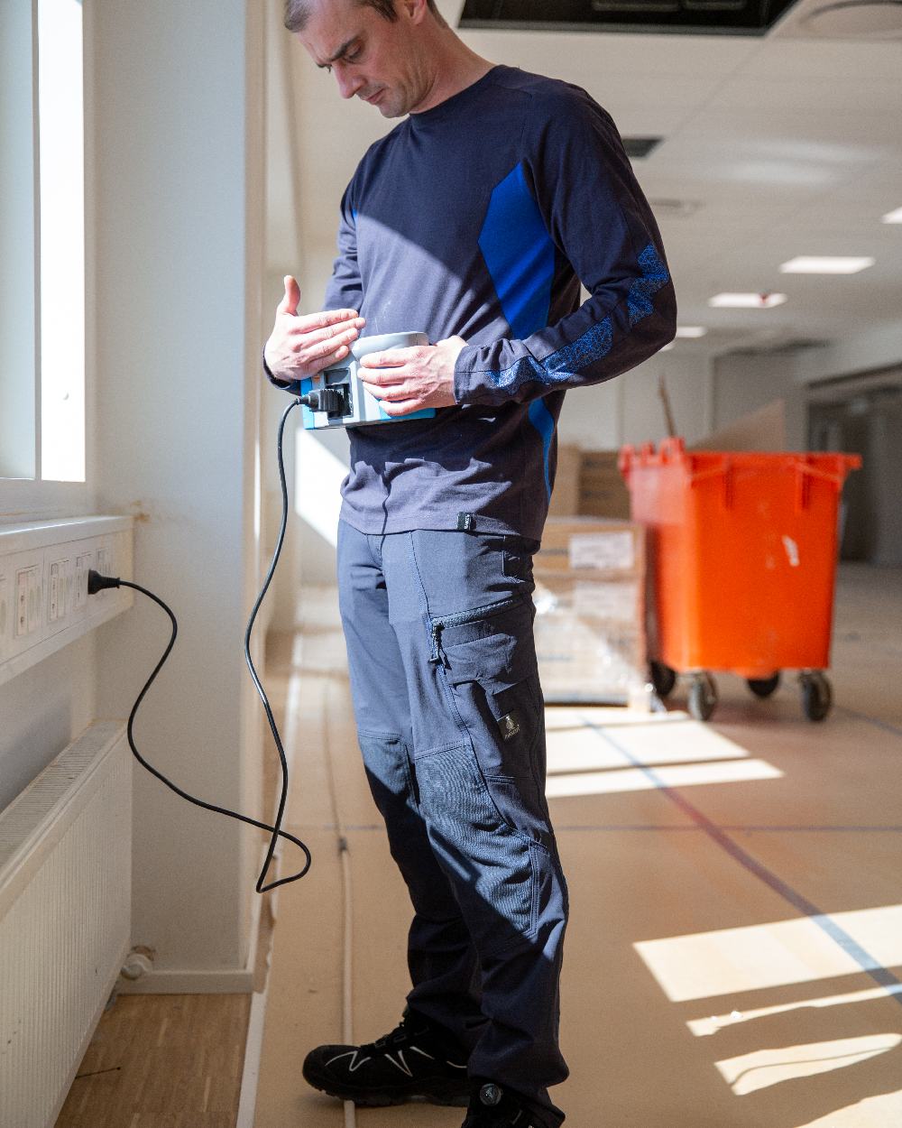 Dark Navy Coloured Mascot Workwear Mens Accelerate Ultimate Stretch Trousers With Kneepad Pockets on construction background
