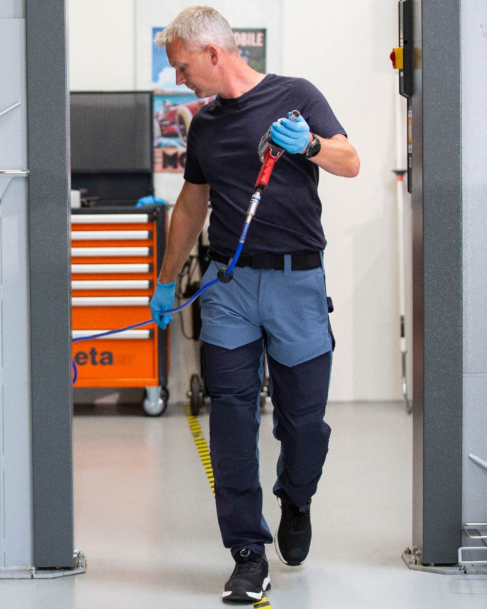 Stone Blue Dark Navy Coloured Mascot Workwear Mens Customized Ultimate Stretch Trousers With Kneepad Pockets on garage background