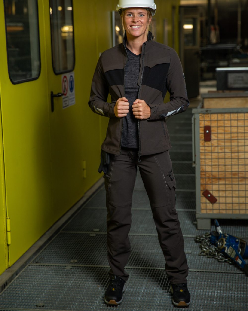 Dark Anthracite Coloured Mascot Workwear Womens Accelerate Trousers With Thigh Pockets on warehouse background
