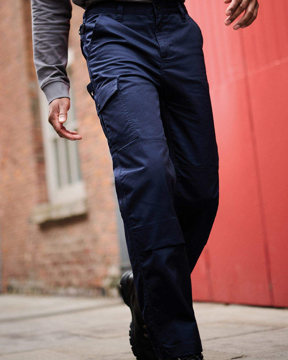 Navy coloured Regatta Pro Cargo Trousers on blurry red background