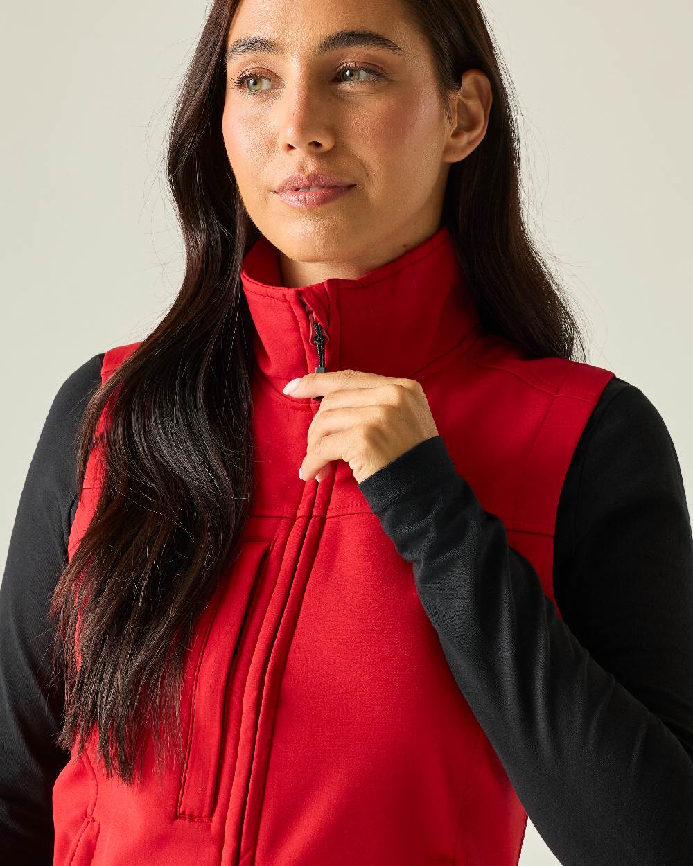 Classic Red coloured Regatta Professional Womens Flux Softshell Bodywarmer on beige background