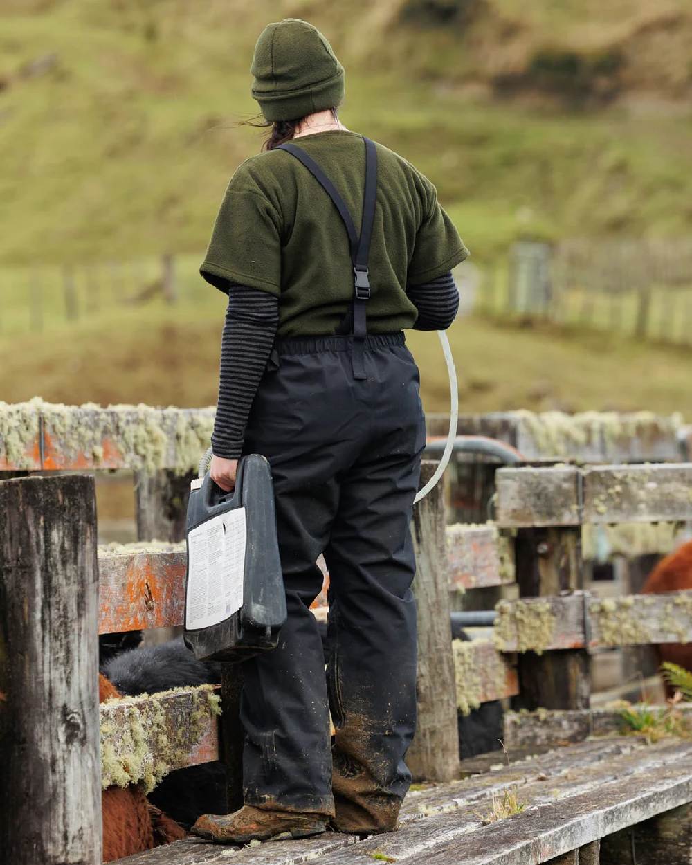 Black coloured Swazi Mens Torrent Bib Overpants on fences background