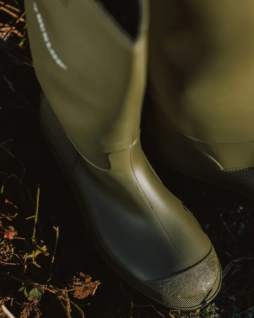 Green coloured Dunlop Pricemastor Wellingtons on blurry background
