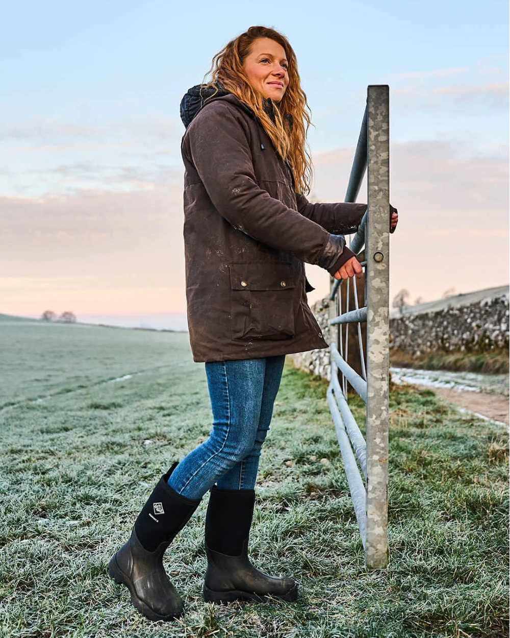 Black Coloured Muck Boots Derwent II Wellingtons On A Field Background