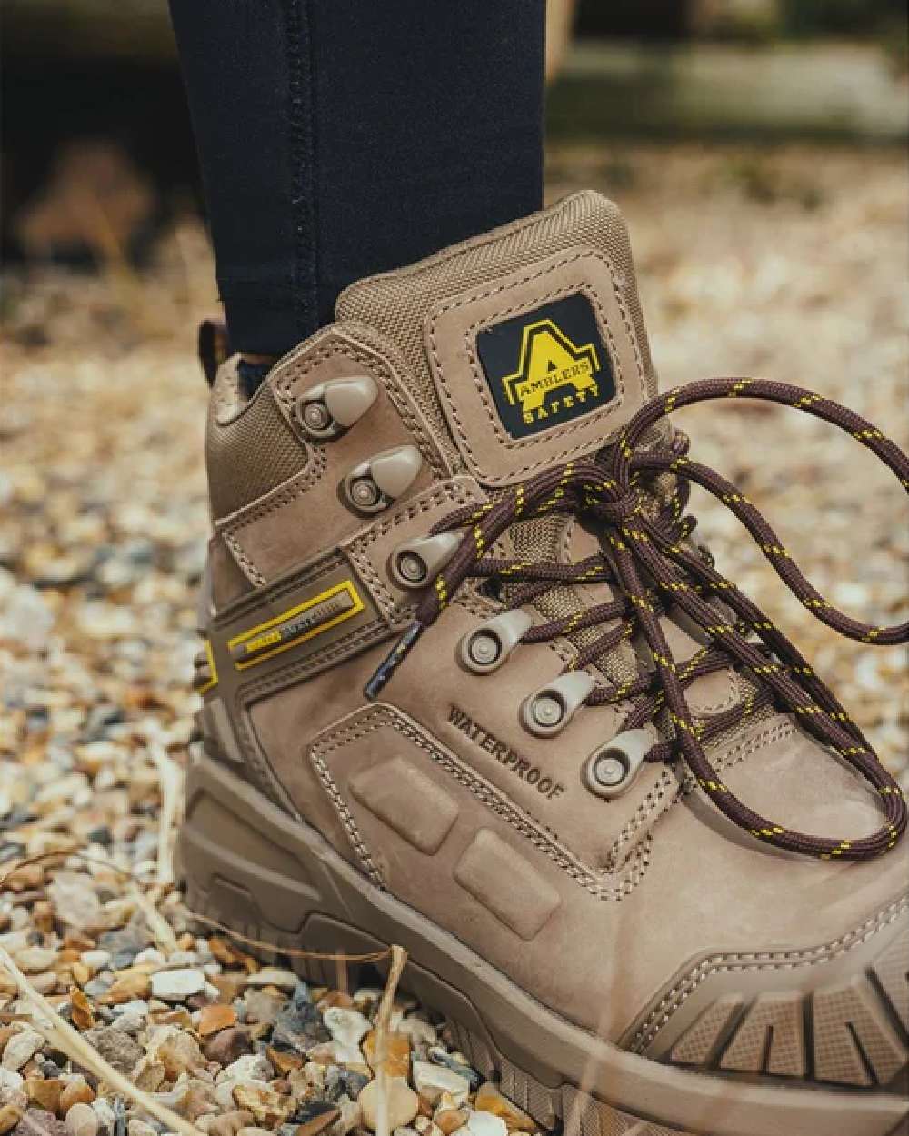 Stone coloured Amblers Safety AS965C Stone Safety Boots on tiny stones background 