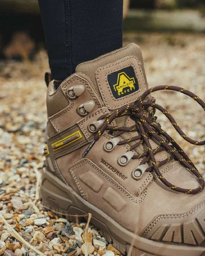 Stone coloured Amblers Safety AS965C Stone Safety Boots on tiny stones background 