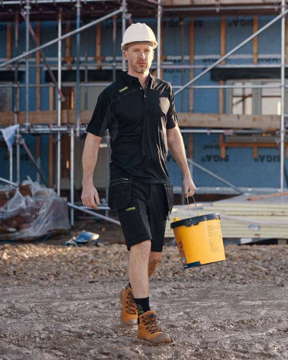 Black Grey Coloured Apache Mens Langley Polo Shirt on construction background 