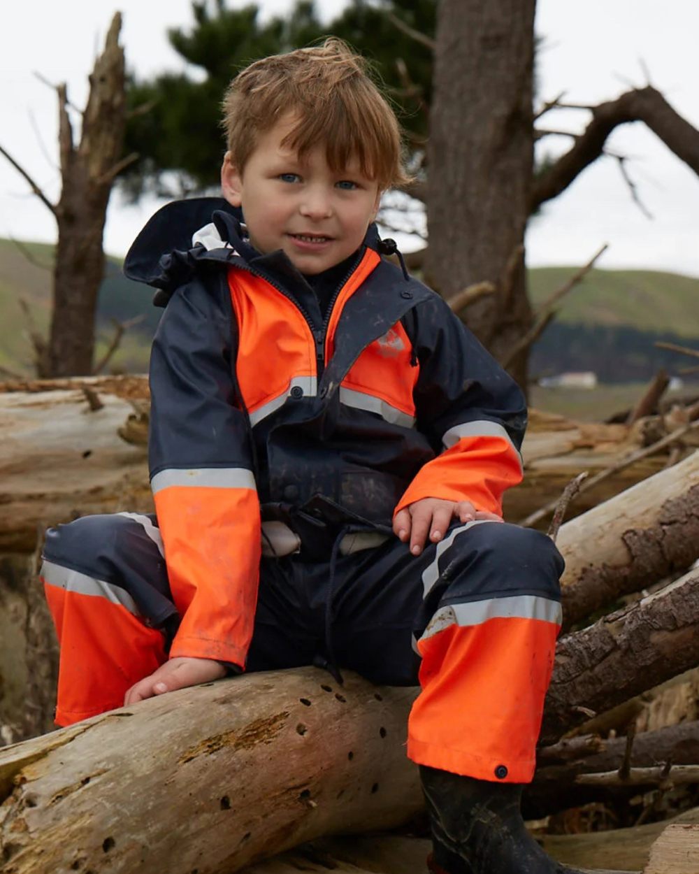 Navy Orange coloured Betacraft Childrens Tuffbak Bib Overtrousers on forest background 