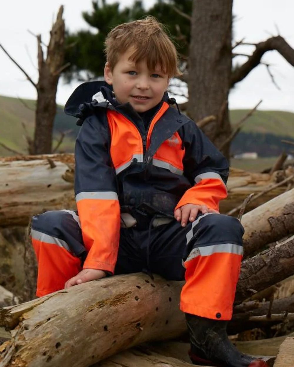 Navy Orange coloured Betacraft Childrens Tuffbak Waterproof Parka on forest background