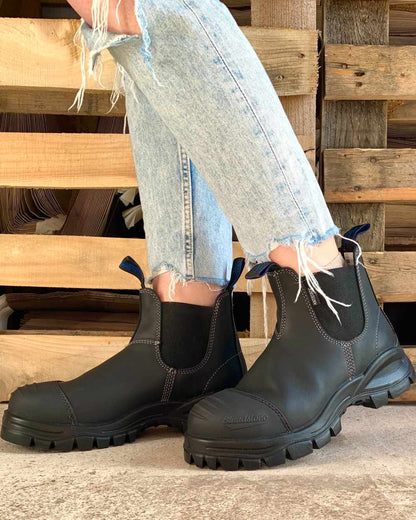 Black coloured Blundstone 910 Black Platinum Safety Boots on street background 