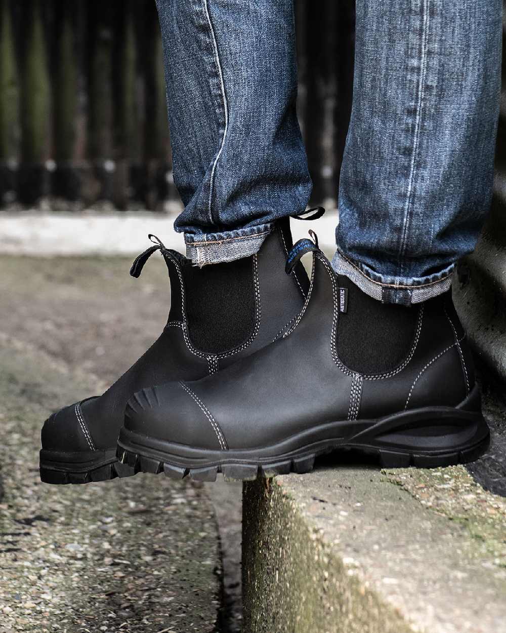 Black coloured Blundstone 910 Black Platinum Safety Boots on street background 