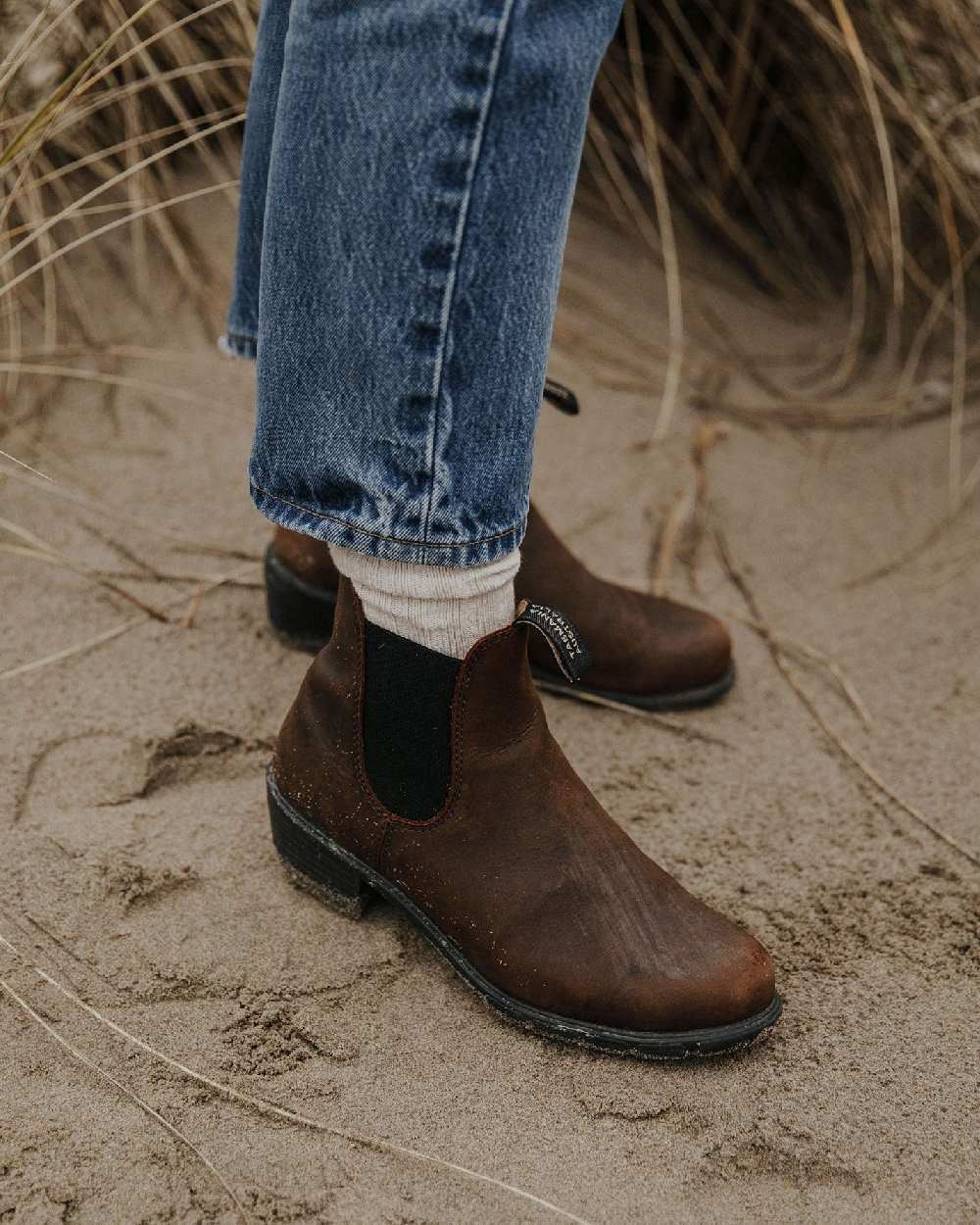Antique Brown coloured Blundstone Womens 1673 Chelsea Boots on sand background 
