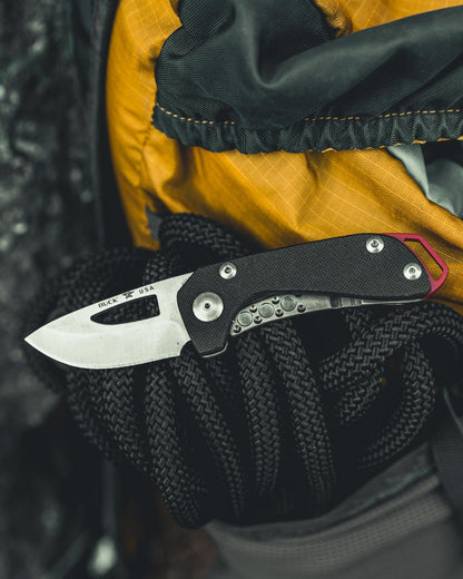 Black coloured Buck Budgie Knife on blurry background 