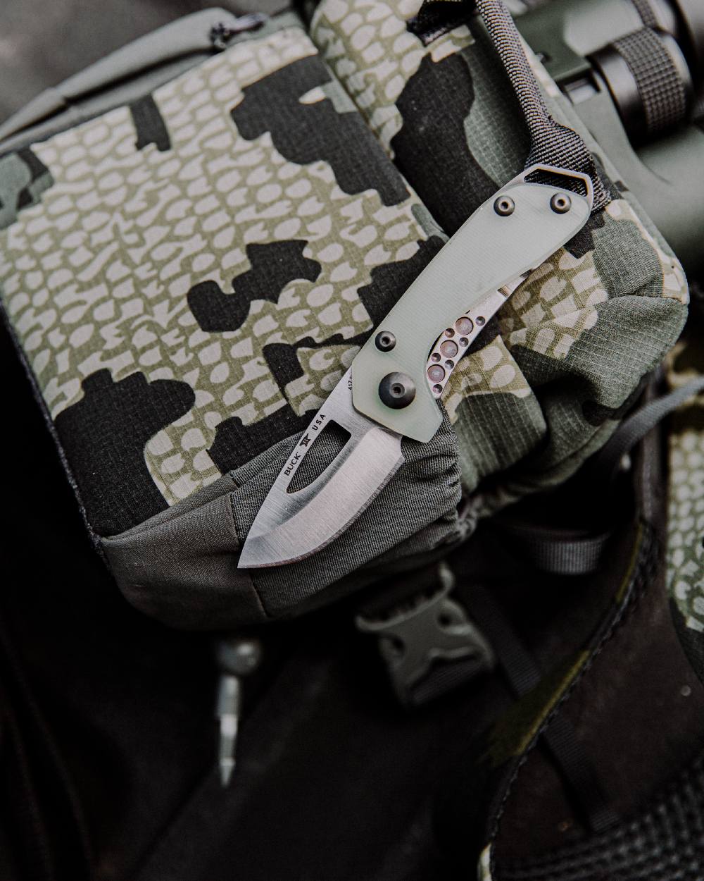 Natural coloured Buck Budgie Knife on bag background 