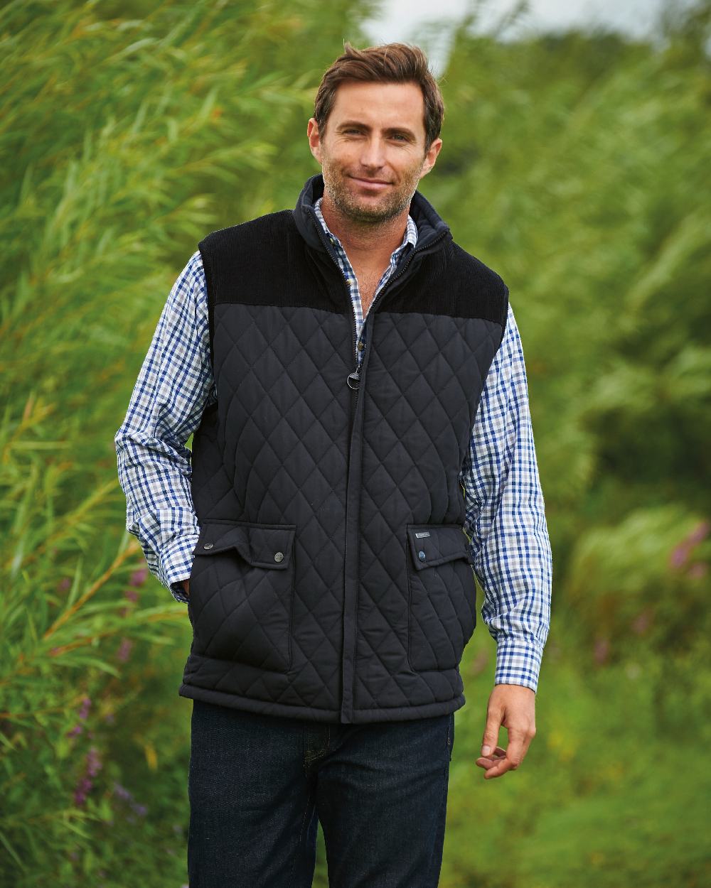 Black coloured Champion Arundel Diamond Quilted Bodywarmer on blurry plants background 