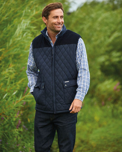 Navy coloured Champion Arundel Diamond Quilted Bodywarmer on blurry plants background 