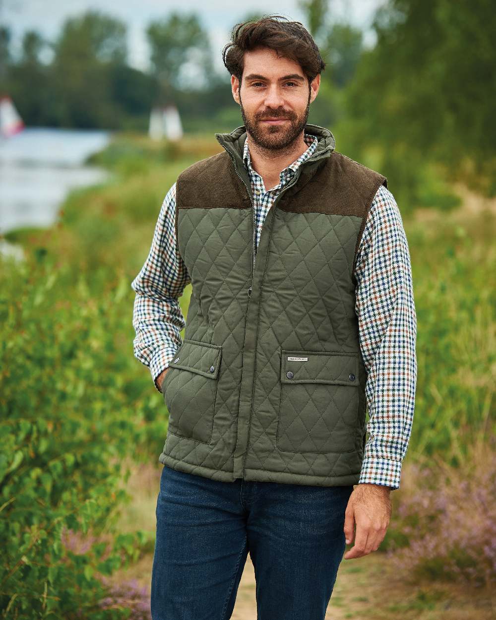 Olive coloured Champion Arundel Diamond Quilted Bodywarmer on blurry forest background 