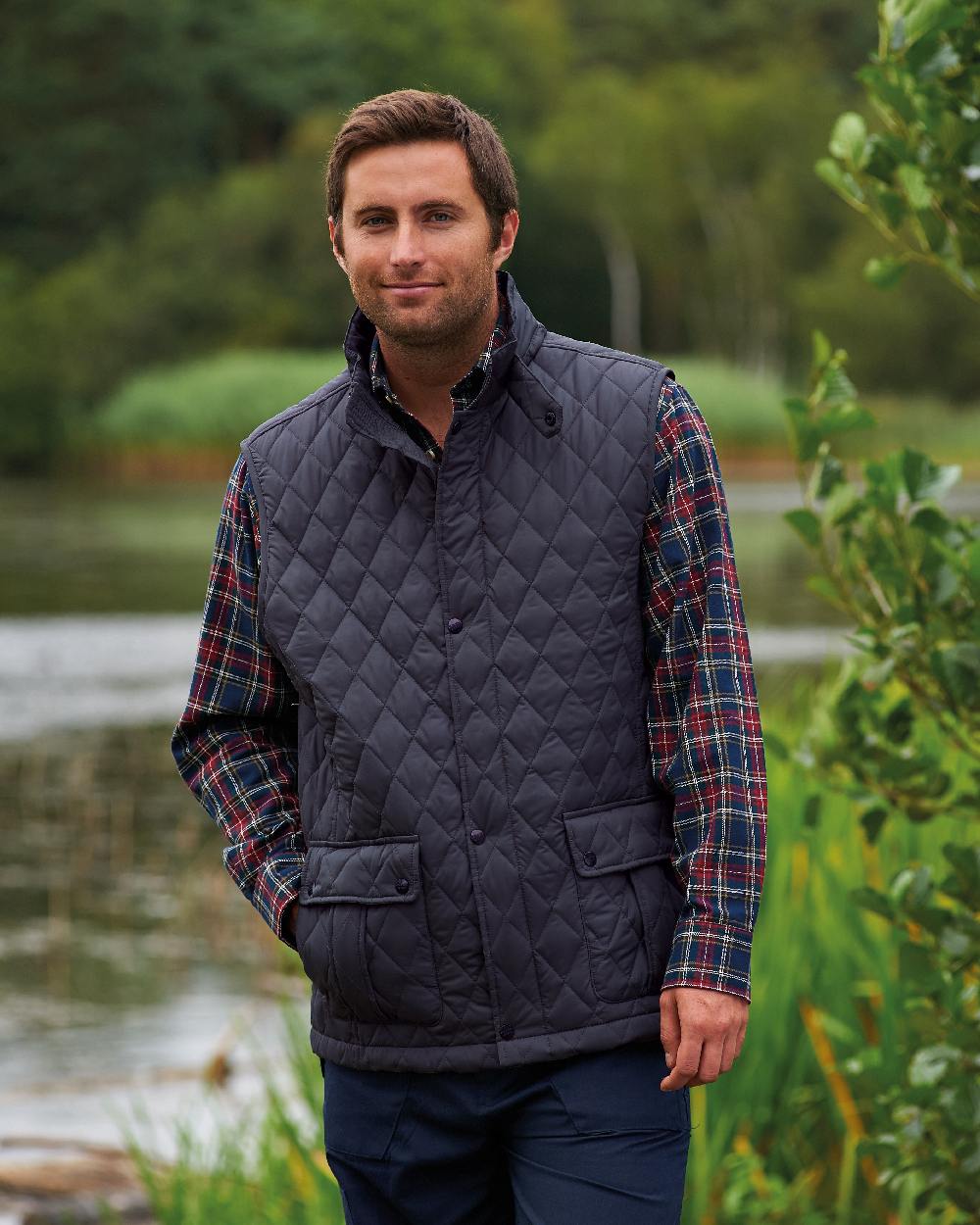 Navy coloured Champion Ashby Quilted Body Warmer on forest background