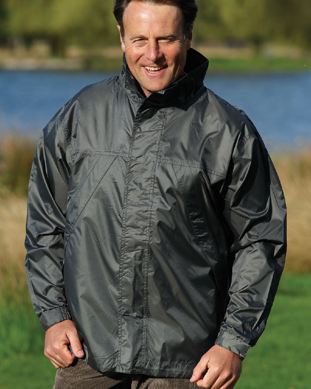 Olive coloured Champion Typhoon Waterproof Shell Jacket on grass background 