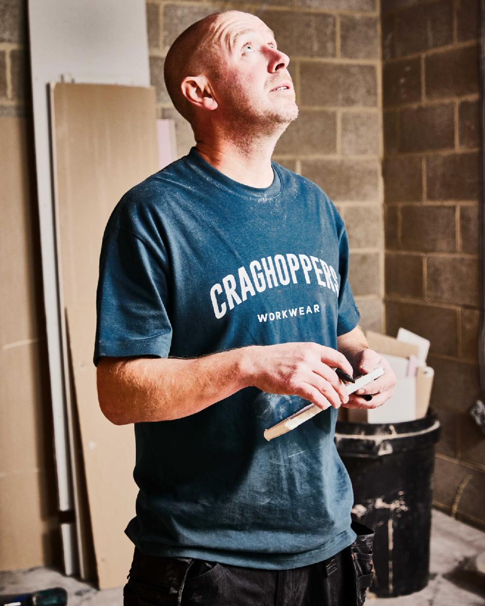 Dark Aegean Blue Coloured Craghoppers Expert Mens Batley Workwear T-Shirt on construction background 
